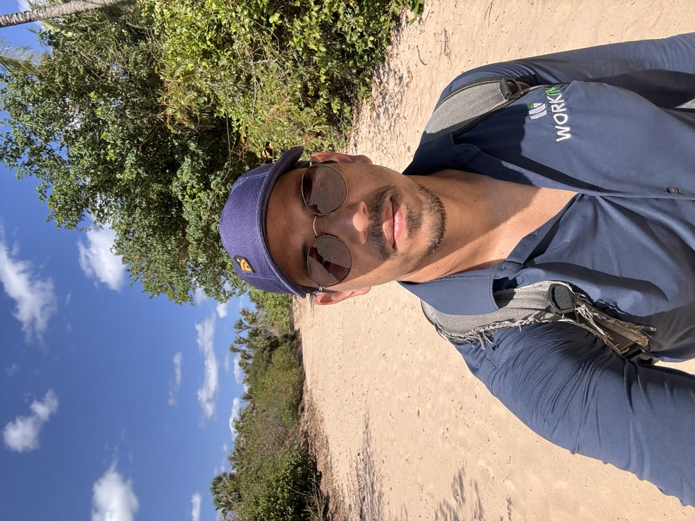 Hugo em trabalho de campo da Workin Agro, com a camisa da Workin numa estrada de areia
